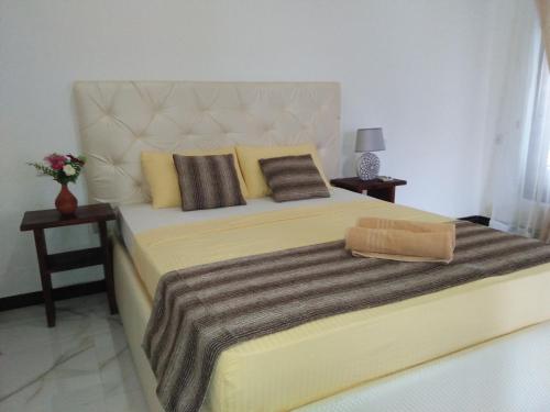 a bedroom with a large yellow bed with two pillows at Living Home in Negombo