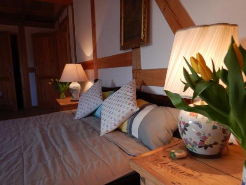 a bedroom with a bed and a table with a lamp at Siedlisko Pod Strzechą in Wólka