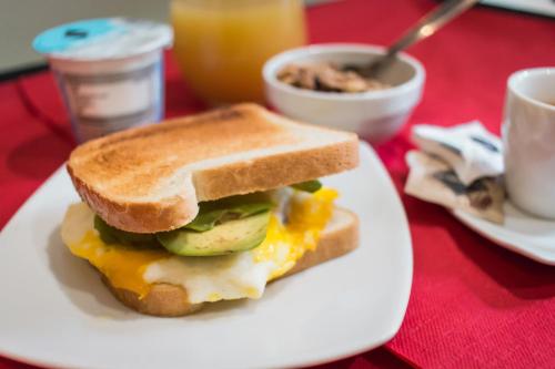 ein Frühstücks-Sandwich auf einem weißen Teller auf einem Tisch in der Unterkunft Hotel Cannaregio 2357 in Venedig