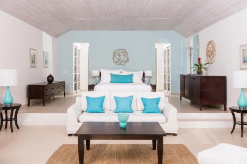 a living room with a white bed and blue pillows at Carlisle Bay in Old Road