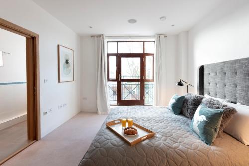 a bedroom with a large bed with a tray on it at Hampden Apartments - The Charles in Windsor