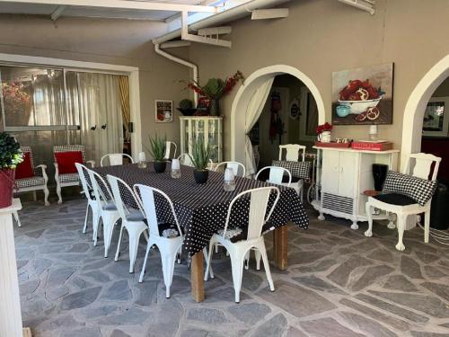 - une table et des chaises en noir et blanc dans la chambre dans l'établissement Tarentaal Guest Farm, à Outjo