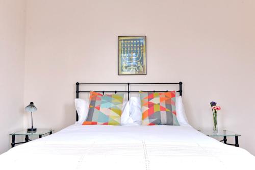 1 dormitorio con 1 cama con sábanas y almohadas blancas en Sea Dreams, en Eastbourne