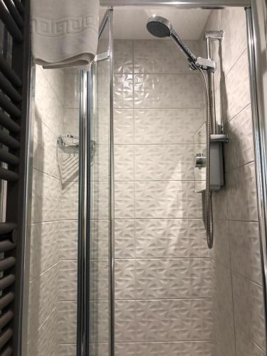 a shower with a glass door in a bathroom at Wordsworths Guest House in Ambleside
