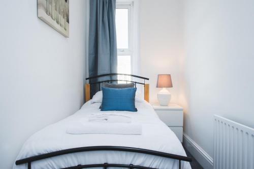 una camera da letto con un letto con un cuscino blu di MyCityHaven - Stylish & Flexible Shirehampton Apartment a Bristol