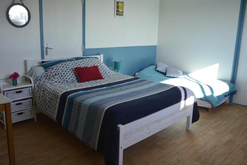 a bedroom with a bed with a red pillow on it at gite Tombelaine in Pontorson