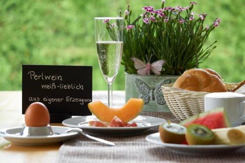 a table with plates of food and a glass of champagne at Landhaus Pannonia in Mörbisch am See