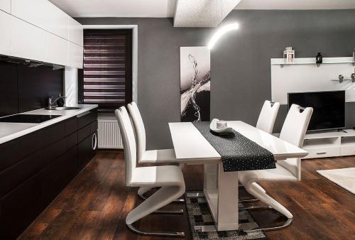 a kitchen with a table and white chairs and a sink at Apartament Alan in Kłodzko