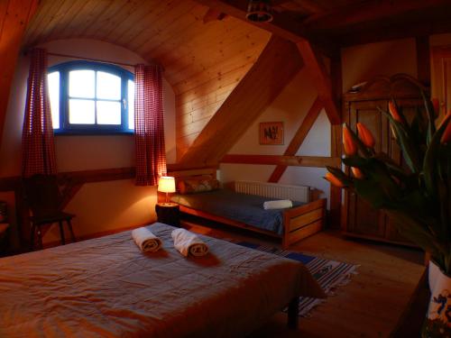 a bedroom with a bed with two towels on it at Siedlisko Pod Strzechą in Wólka