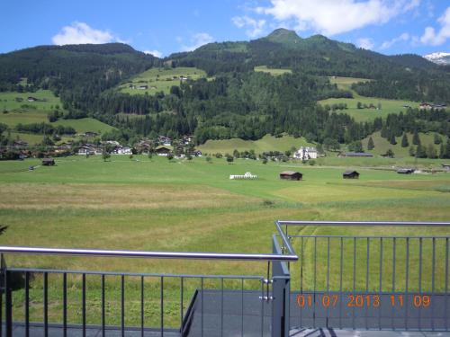 a view of a green field with mountains in the background at Fuchs Apartments - inklusive Eintritt in die Alpentherme Gastein in Bad Hofgastein