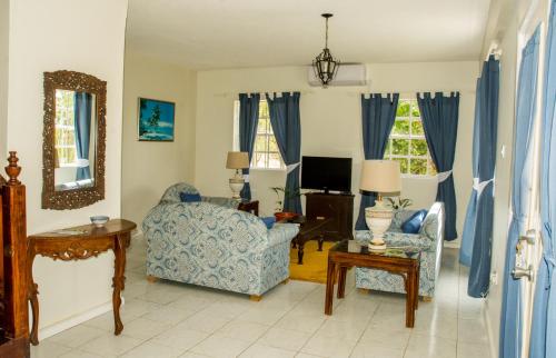 a living room with a blue couch and a chair at Castles In Paradise Villa Resort in Vieux Fort