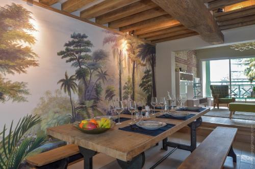 une salle à manger avec une table et un tableau au mur dans l'établissement La Maison de Pierre et Valérie St Leonard Honfleur, à Honfleur