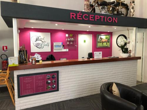 a bar in a restaurant with pink walls at Hotel Du Golf in Cabourg