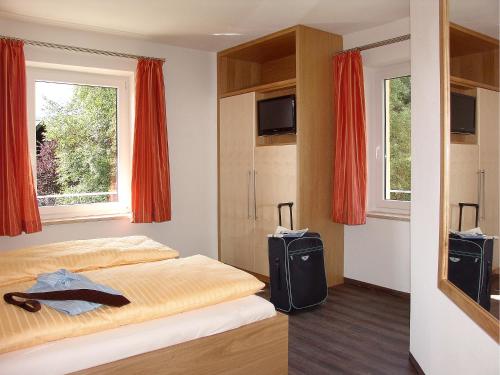 ein Schlafzimmer mit einem Bett und einem Fernseher darin in der Unterkunft Fellhornhaus Ferienwohnungen in Oberstdorf