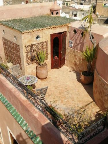 a patio with chairs and a red door on a house at Les Bains de Fez Tara in Fès