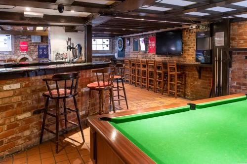 a bar with a pool table and bar stools at The Crown Hotel in Alton