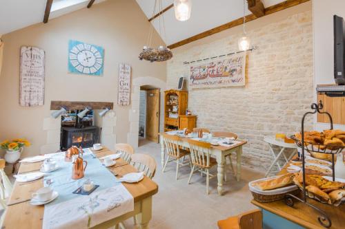 une salle à manger avec des tables et une cheminée dans l'établissement The Old Farm of Amfreville, à Amfreville
