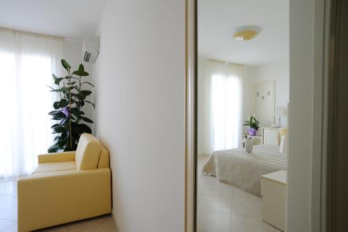 a mirror in a room with a bed and a couch at Residence Suite Smeraldo in Riccione