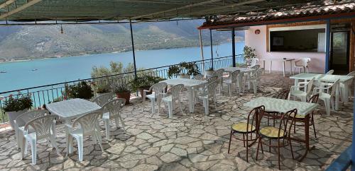 a patio with tables and chairs and a view of the water at Panorama Plataria Ionio Studios&Apartments in Plataria