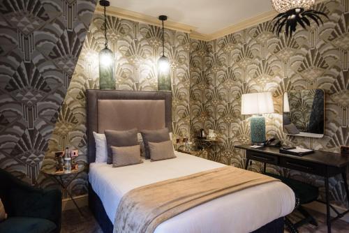 a bedroom with a bed and a desk and a mirror at The Spa Hotel in Royal Tunbridge Wells