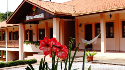 a building with a red flower in front of it at Hotel Fazenda Itáytyba in Tibagi