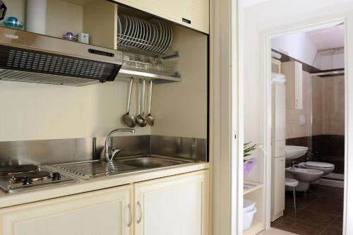 cocina con fregadero y fogones horno superior en Residence Suite Smeraldo, en Riccione