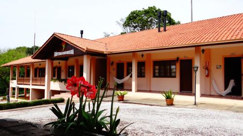 a building with a red flower in front of it at Hotel Fazenda Itáytyba in Tibagi