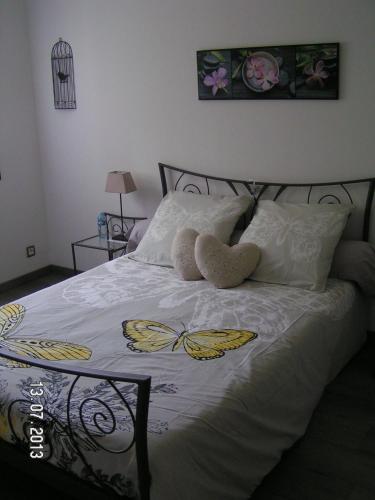 - une chambre dotée d'un lit avec 2 papillons farcis dans l'établissement Les champs dorés, à Noyarey