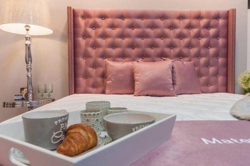 un letto con vassoio bianco con croissant e tazze di Hotel City Pisek a Písek