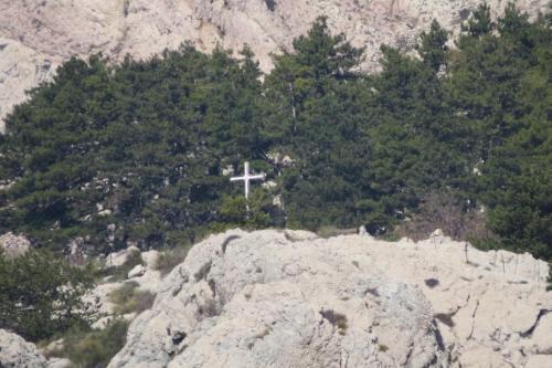 a cross on top of a mountain with trees at Apartments Authentic Baska in Baška