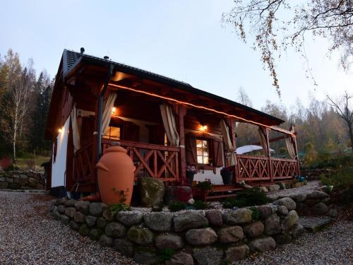 a small house with a stone wall in front of it at Domek w Karkonoszach in Przesieka