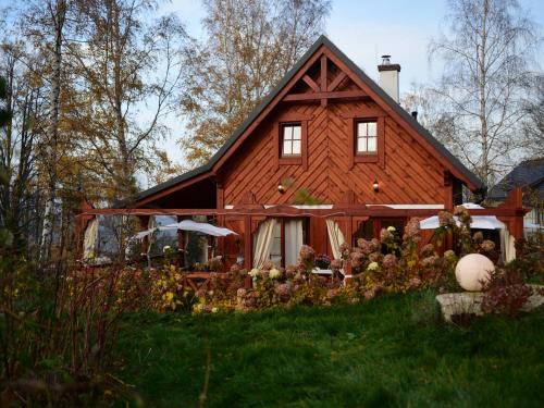 a large wooden house in the middle of a yard at Domek w Karkonoszach in Przesieka