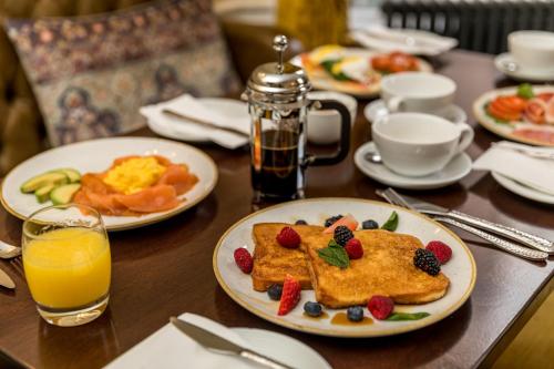 a table with plates of breakfast foods and orange juice at Stauntons on the Green Hotel in Dublin