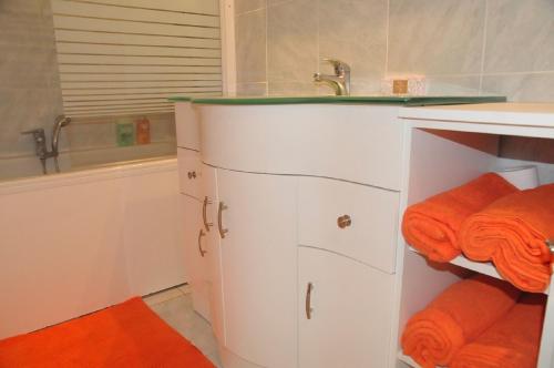 a bathroom with a sink and orange towels at le havre de paix in Annecy