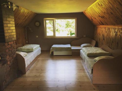 a room with three beds and a window at Valuntynė in Plokščiai