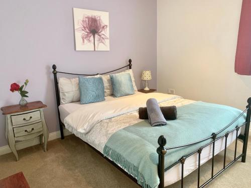 a bedroom with a bed and a table with a nightstand at Lahnstein Court in Kettering