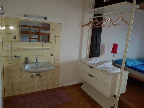 een badkamer met een wastafel en een bed bij Auberge de la Couronne in Saignelégier