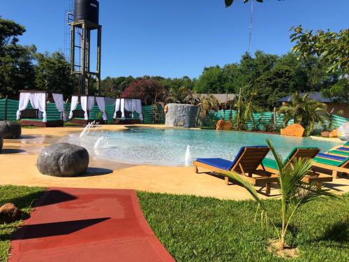 una piscina con 2 sillas y una fuente en Z Hotel Boutique en Puerto Iguazú