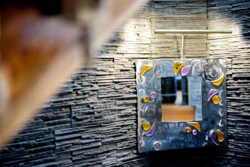 a mirror in a room with a stone wall at La Sainte Famille in Lourdes