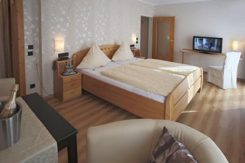 バート・ベルトリッヒにあるHotel Haus Christaのベッドとテレビが備わるホテルルームです。