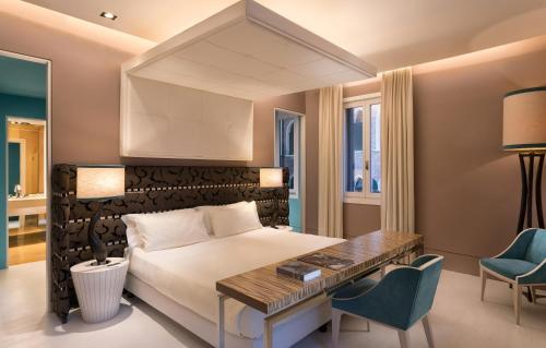 a bedroom with a bed and a desk and chairs at Sina Centurion Palace in Venice