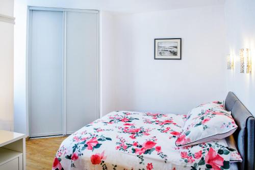 a bedroom with a bed with a floral comforter at La Sainte Famille in Lourdes