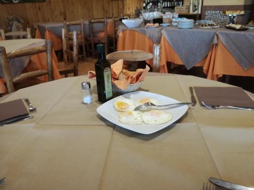 a plate of eggs and a bottle of wine on a table at Albergo Ristorante Uliveto in Veroli