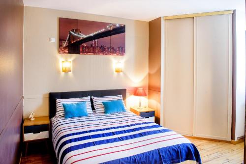 a bedroom with a large bed with blue pillows at La Sainte Famille in Lourdes