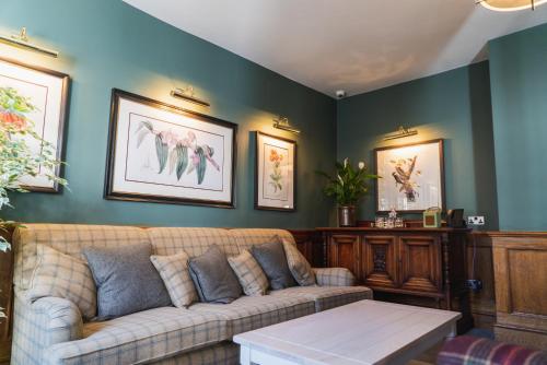 a living room with a couch and paintings on the wall at The Highdown – Brunning and Price in Worthing