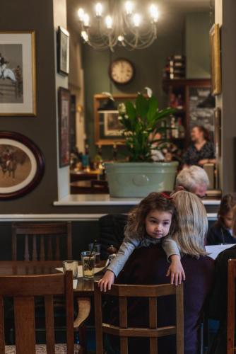 a little girl sitting in a chair in a restaurant at The Highdown – Brunning and Price in Worthing