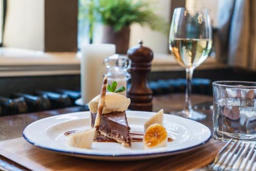 a plate of dessert on a table with a glass of wine at The Highdown – Brunning and Price in Worthing