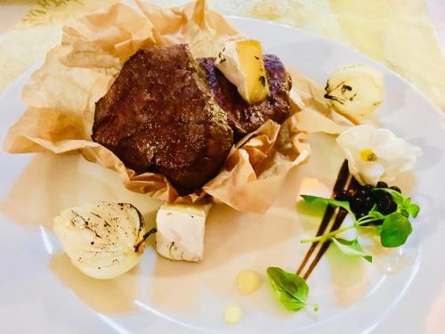 a piece of meat and cheese on a white plate at Neptun in Międzychód