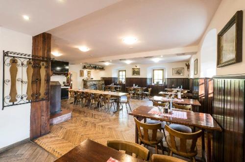 a restaurant with wooden tables and wooden chairs and tables at Restaurace a penzion Stará pošta in Bečov nad Teplou