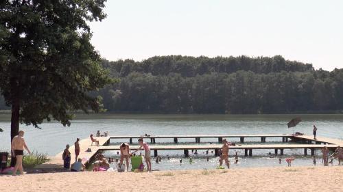 eine Gruppe von Menschen an einem Strand in der Nähe eines Docks in der Unterkunft Apartament przy plaży free parking in Złotów
